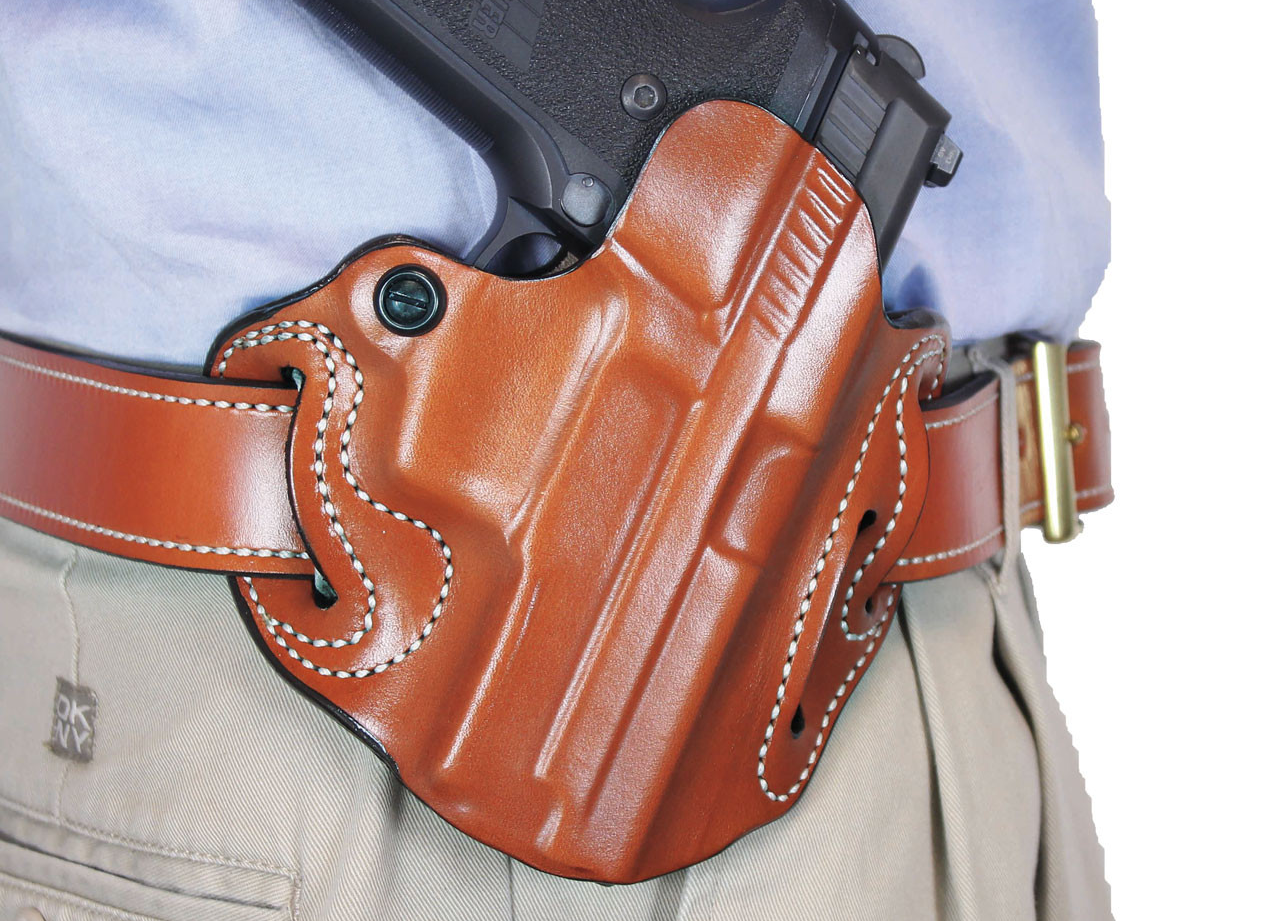 Close-up view of a strong-side hip carry leather holster holding a handgun on a belt.
