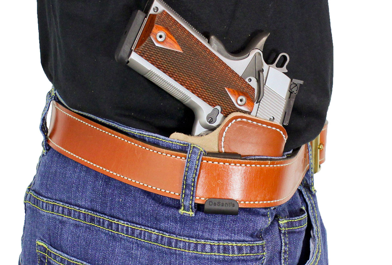 Person wearing a strong-side hip carry holster with a handgun positioned on the outside of the waistband.